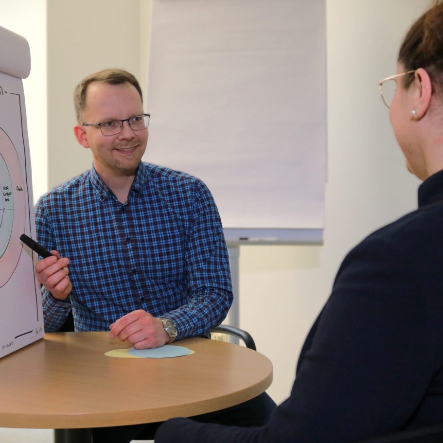 Mann am Tisch mit Frau im Gespräch